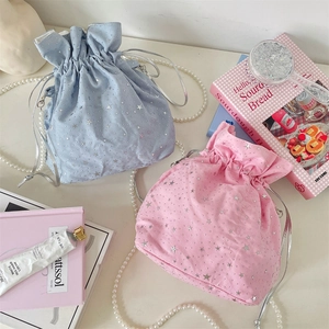 Dettaglio di borse tote in tela con coulisse rosa e blu con motivi a stelle argentate
