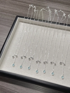 Macro shot of silver teardrop sapphire pendants neatly displayed on a jewelry tray