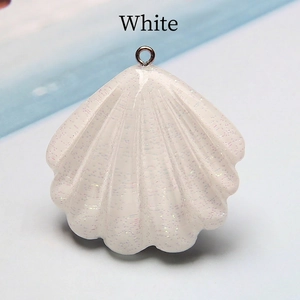 Macro shot of white shell-shaped resin pendant with iridescent glitter and silver ring