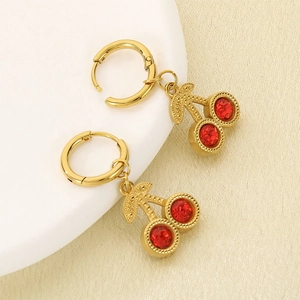 Detailed close-up of gold cherry earrings with red faceted stones and leaf texture