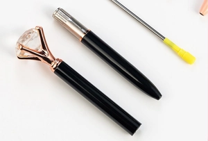Close-up of black metal diamond pen with rose gold clip and elegant crystal top