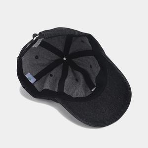 Detail view of denim baseball cap interior featuring a 6-panel structure and metal buckle