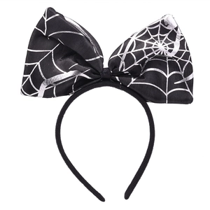 Détail d'un serre-tête noir avec un nœud à motif de toile d'araignée argentée pour Halloween