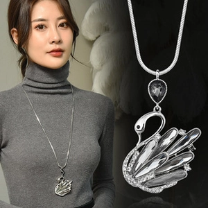 Detail of silver swan pendant necklace with grey crystals on a sleek snake chain