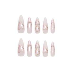 Handmade almond press-on nails in pearly pink featuring 3D golden heart silhouettes