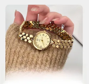 Close-up of Gedi gold watch with honeycomb chain bracelet and Roman numeral dial