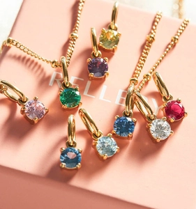 Macro shot of colorful round-cut birthstone pendants in gold four-prong settings
