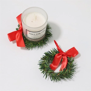 Detail eines Weihnachts-Serviettenrings mit künstlichen Kiefernnadeln und roter Schleife