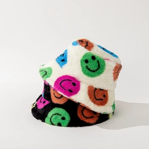 Close-up of plush bucket hats with colorful smiley faces in black and white styles