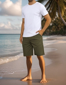 Army green men's loose fitness shorts styled at a tropical beach with white t-shirt