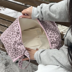 Close-up of leopard print tote bag interior featuring spacious lining and a zipper pocket