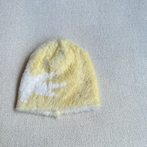 Close-up of plush yellow star pattern knit beanie showing soft fuzzy texture