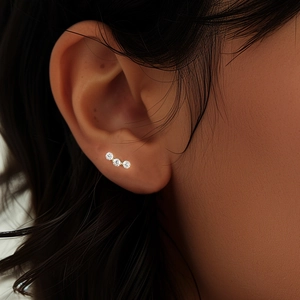 Macro shot of 925 sterling silver three-stone cz cartilage piercing on a model's ear