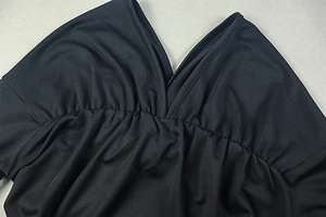 Close-up of V-neckline detail with pleated chest design on a black two-piece dress set