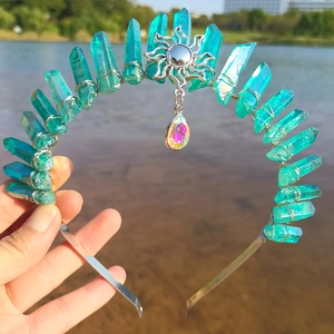 Detailed shot of handmade crystal crown with sun charm and blue quartz on a silver headband