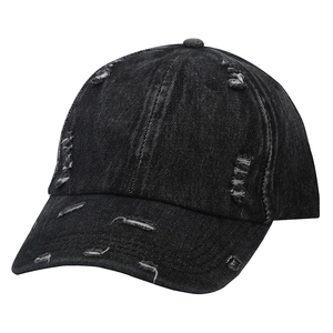 Close-up of a distressed black denim baseball cap with stylish ripped holes and vintage finish