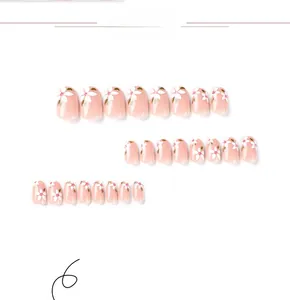 Detailed flat lay of pink press-on nails with white floral patterns and red dots detail