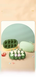 Detail view of green 8-hole silicone popsicle mold with cute crocodile lid and mini sticks