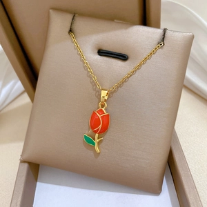 Detailed close-up of a golden tulip pendant with red enamel flower and green leaves inlay