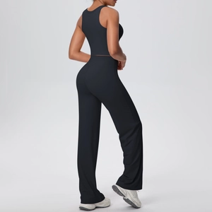 Vista laterale del crop top nero a vogatore e dei pantaloni yoga a gamba larga