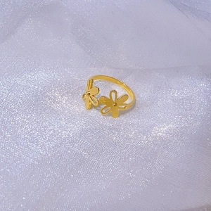 Gros plan d'une bague tournesol dorée sur un fond de tissu blanc scintillant