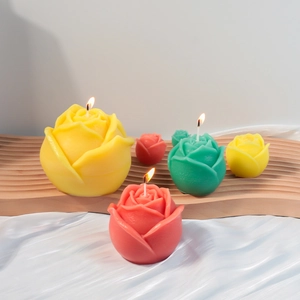 Drie maten rozengeurkaarsen in rood, geel en groen op een houten dienblad