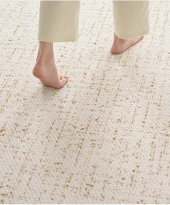 Close-up of soft beige cream carpet texture with bare feet showing comfort and retro pattern