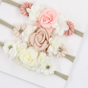 Detailed view of three-piece baby flower headbands with rhinestones and nylon elastic straps