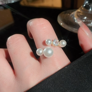 Detail of gold-plated C-shaped ring featuring elegant pearls and a sparkling zircon stone