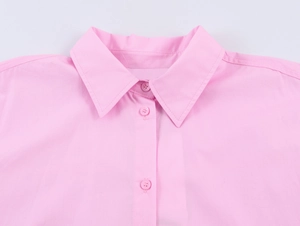 Detailed view of pink poplin shirt collar with matching resin buttons and fine stitching