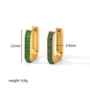 Detail view of gold hoop earrings with emerald green rectangular cubic zirconia