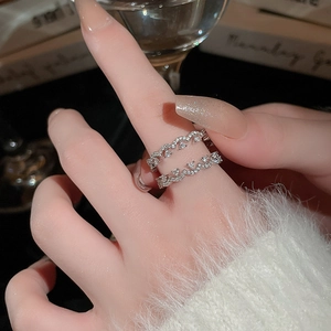Detail of elegant double-layered wave ring with sparkling zircons on model's hand