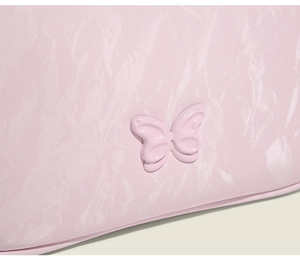 Detail of pink pleated texture underarm bag with 3D butterfly ornament and PU finish