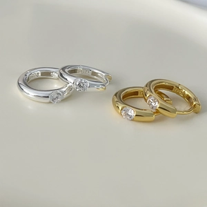 Macro shot of silver and gold S925 sterling silver hoop earrings with zircon stones