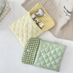 Dettaglio della trapuntatura a cuore e chiusura a scatto su pochette dai colori pastello