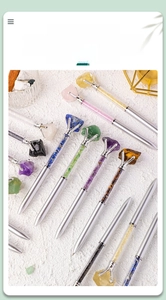 Macro detail of various natural crystal gemstones inside a silver metallic ballpoint pen