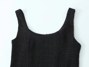 Close-up of black tweed sleeveless top showing U-neckline and detailed fabric texture