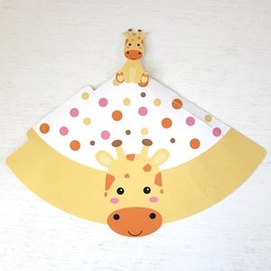 Flat lay of DIY giraffe party hat showing yellow polka dots and cartoon face detail