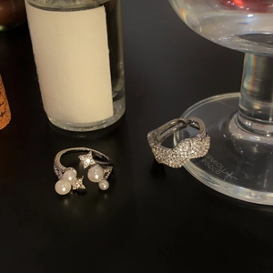 Nahaufnahme eleganter Zirkonia-Stern-Perlen-Ringe auf einer edlen dunklen Fläche