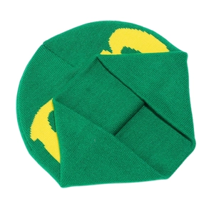 Close-up of green knitted beanie showing textured fabric and yellow jacquard lettering