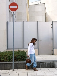 Λεπτομέρεια από λευκό βαμβακερό μακρυμάνικο T-shirt με τύπωμα ether και φαρδύ τζιν