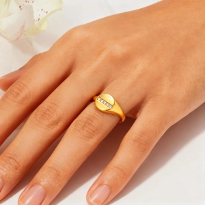 Close-up of minimalist gold ring with row of white diamonds on model finger