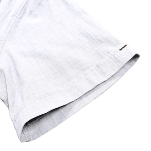 Close-up of light gray cotton linen shirt sleeve showing fine fabric texture and stitching