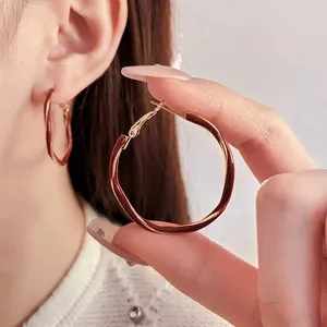 French retro gold twist hoop earrings with deep red enamel coating for elegant women