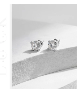 Macro view of 1 carat round moissanite earrings in classic silver four-prong setting
