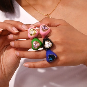 Close-up of five colorful 18K gold plated heart-shaped rings with faceted crystals