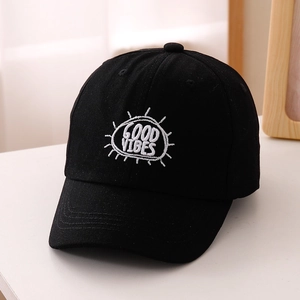 Dettaglio del ricamo bianco GOOD VIBES su un berretto da baseball nero in cotone