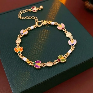 Vintage gold-plated bracelet featuring colorful enamel butterfly charms on a jewelry box