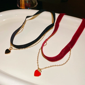 Detail of red and black velvet heart pendants with a golden chain choker necklace