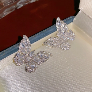 Macro shot of silver butterfly stud earrings with sparkling cubic zirconia in a jewelry box